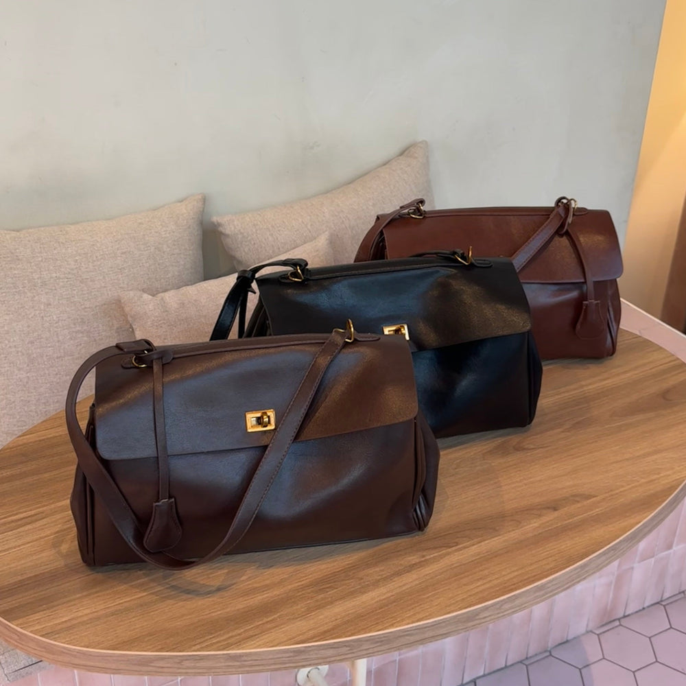 Dark brown leather shoulder bag with a long strap and gold-tone clasp