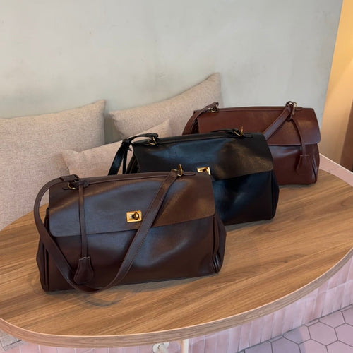 Dark brown leather shoulder bag with a long strap and gold-tone clasp