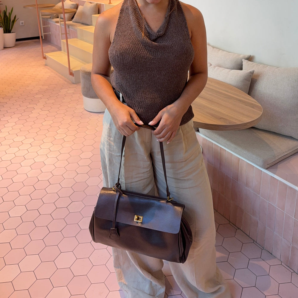 Ciara Vintage shoulder bag carried by its long strap, with a gold-tone clasp