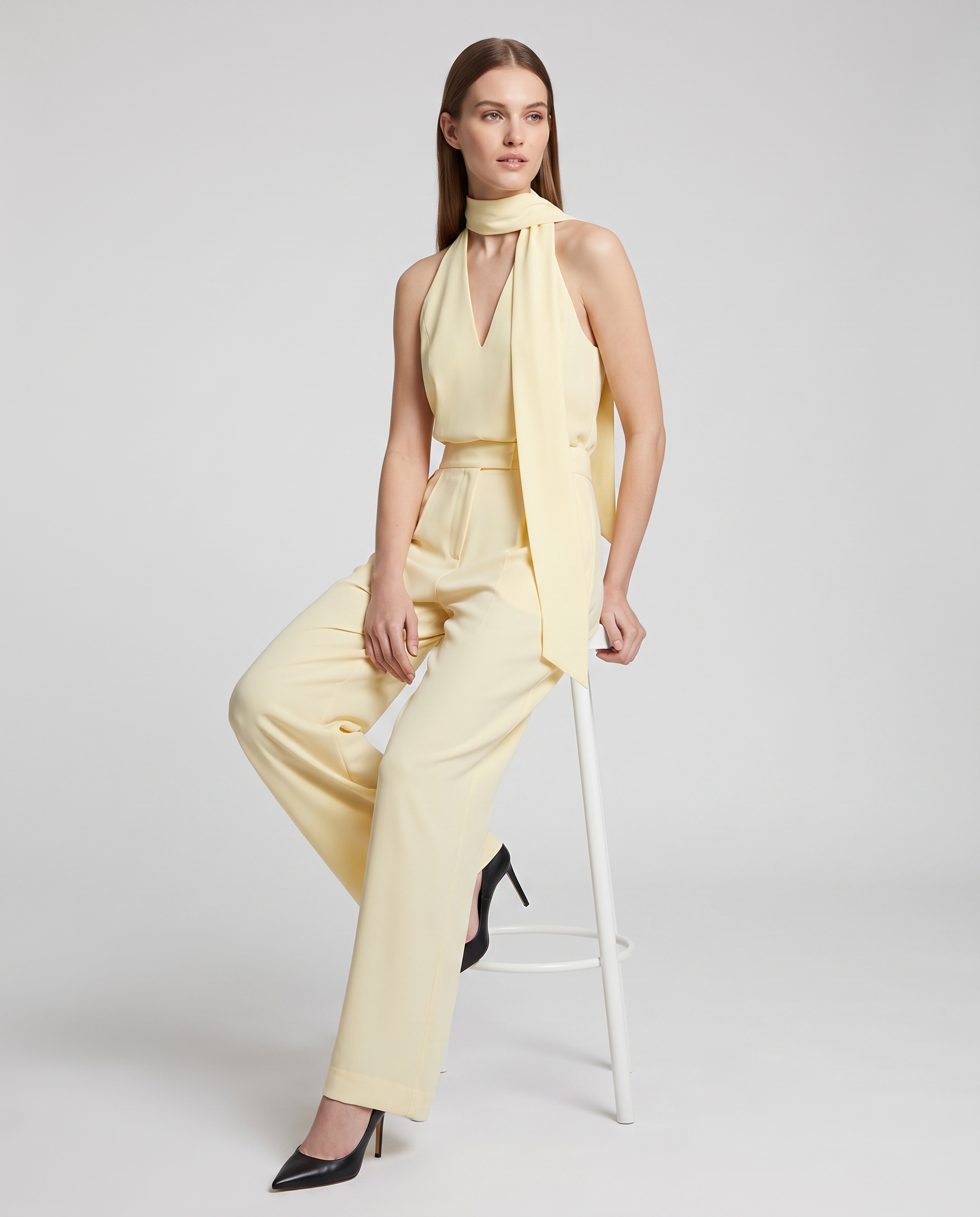 Women's yellow halter neck wide-leg jumpsuit with sash tie and tapered drape