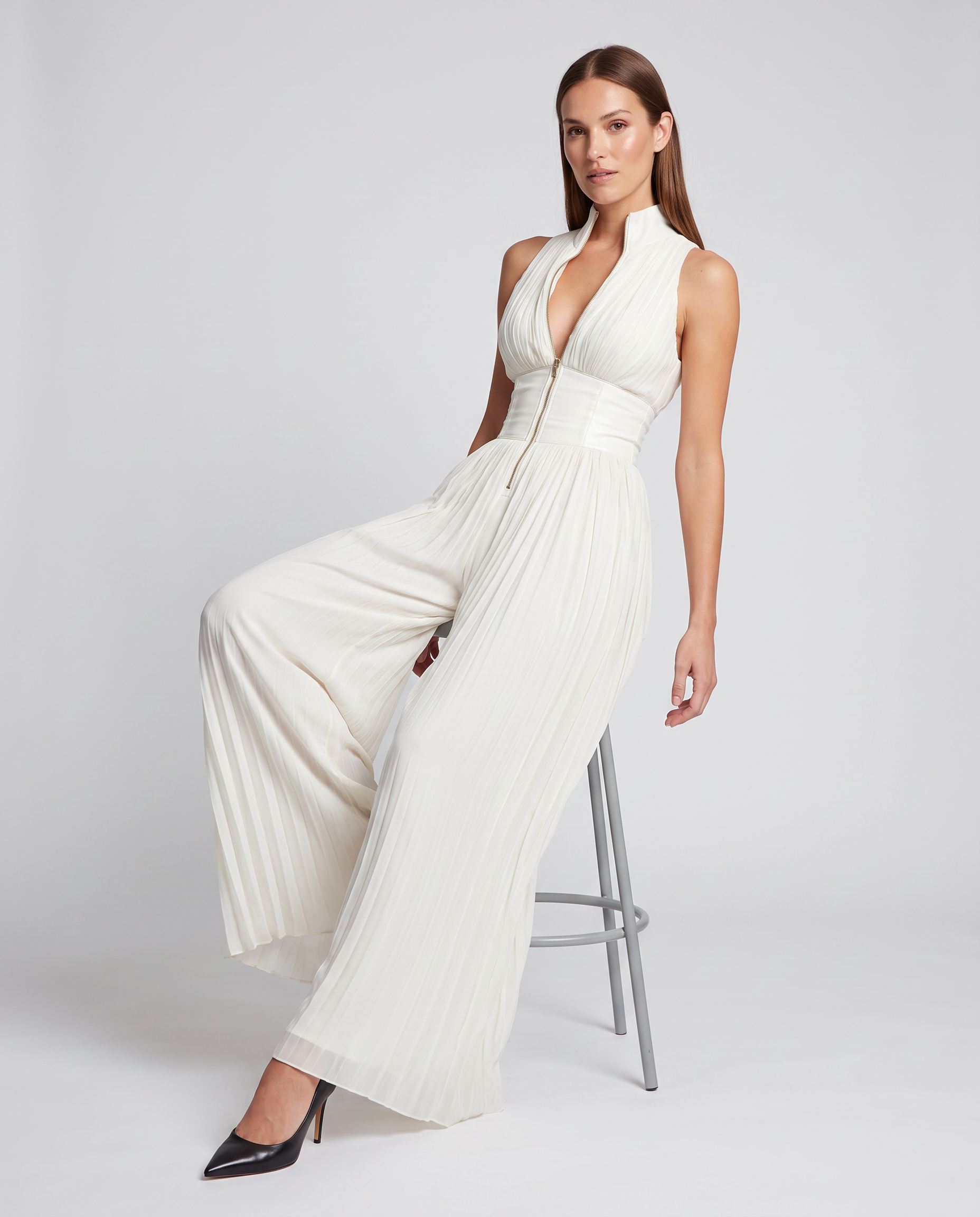 White pleated wide-leg jumpsuit with deep V halter neckline and gathered waist