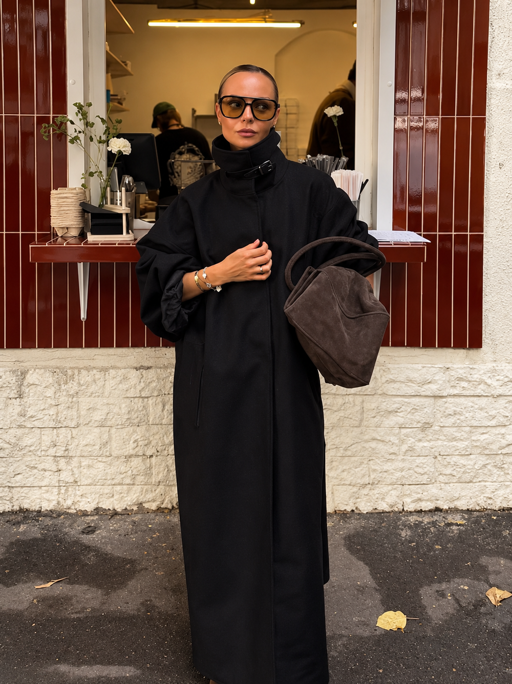 Black trench coat with lace-up funnel neck, button front, and wide sleeves