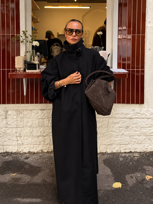 Black trench coat with lace-up funnel neck, button front, and wide sleeves