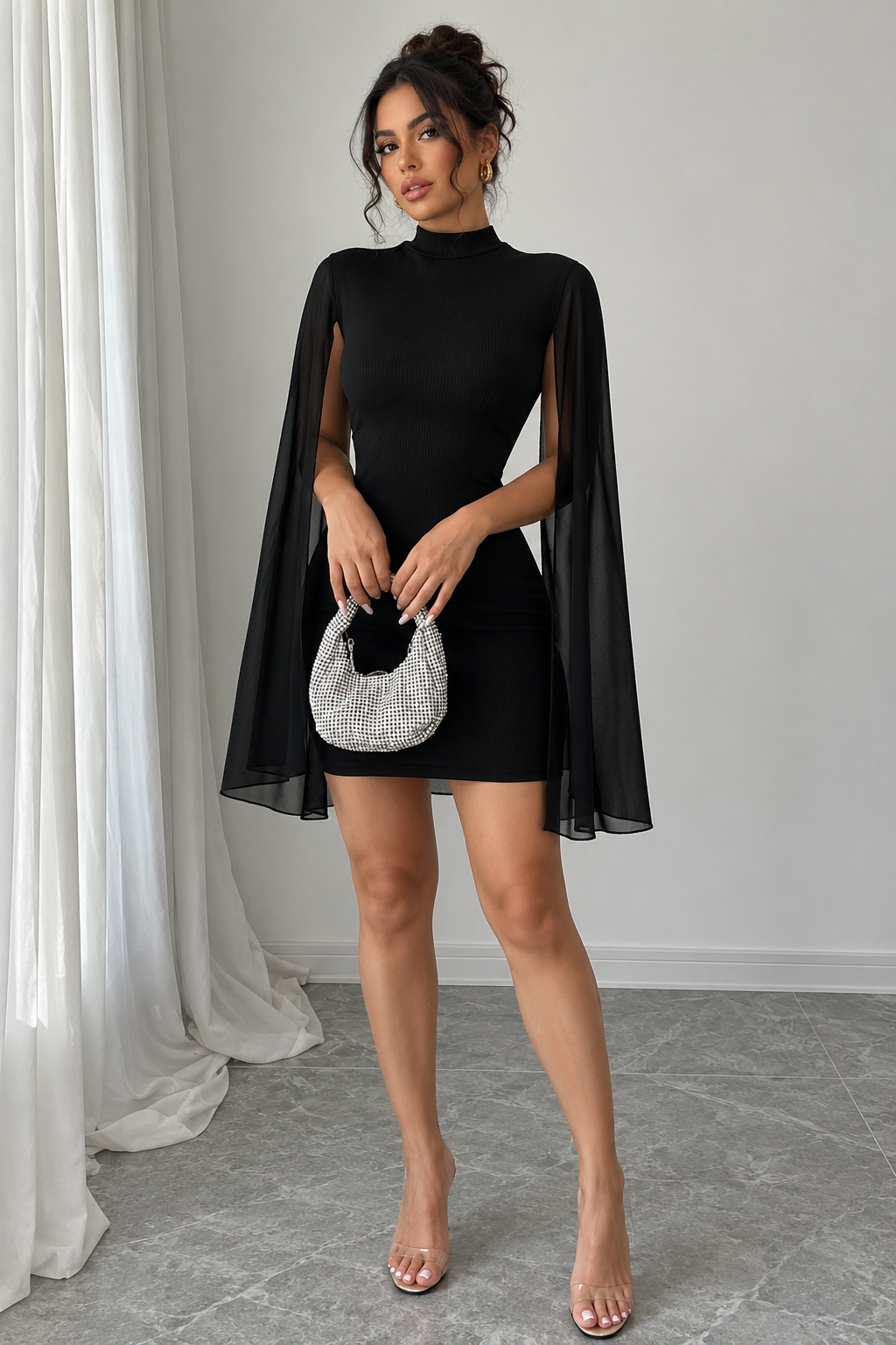 Black bodycon dress with draped sheer cape overlay and high neckline