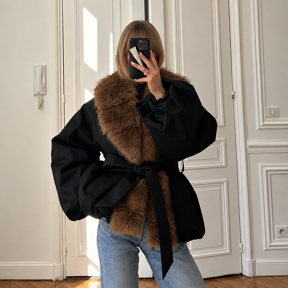 Black quilted puffer bomber with brown fur collar and tie-belt at waist