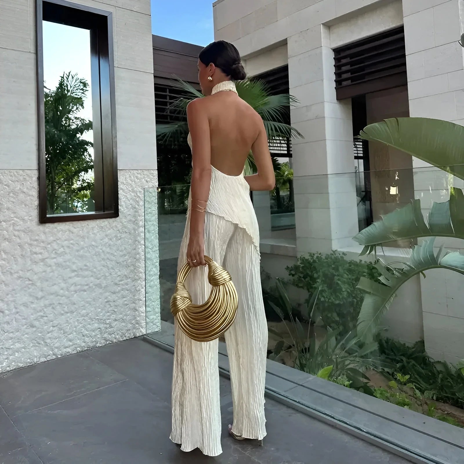 Ivory pleated halter co-ord set with open-back top and flowing wide-leg pants