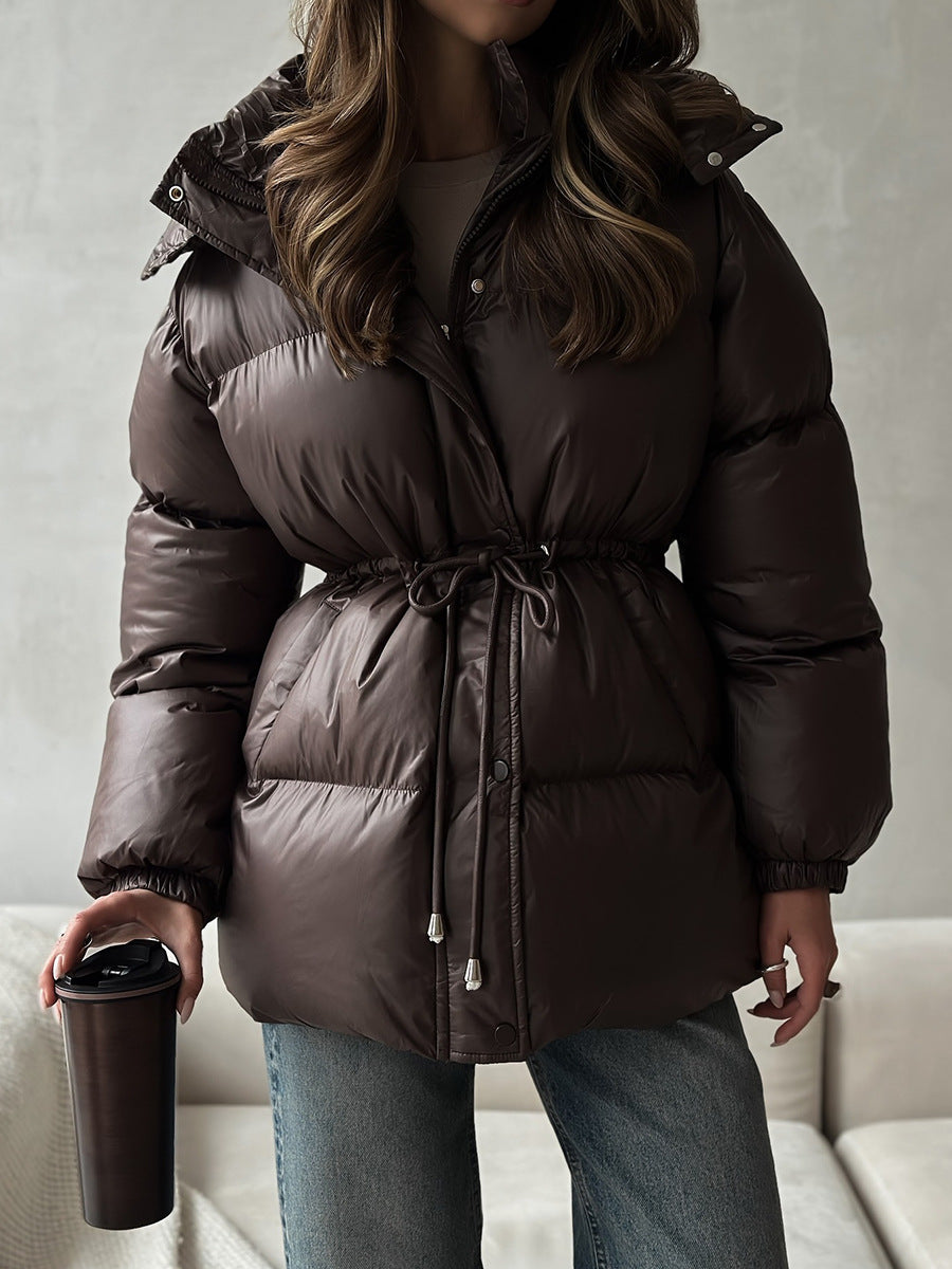 Dark gray women’s hooded puffer jacket with cinched drawstring waist and zipper front