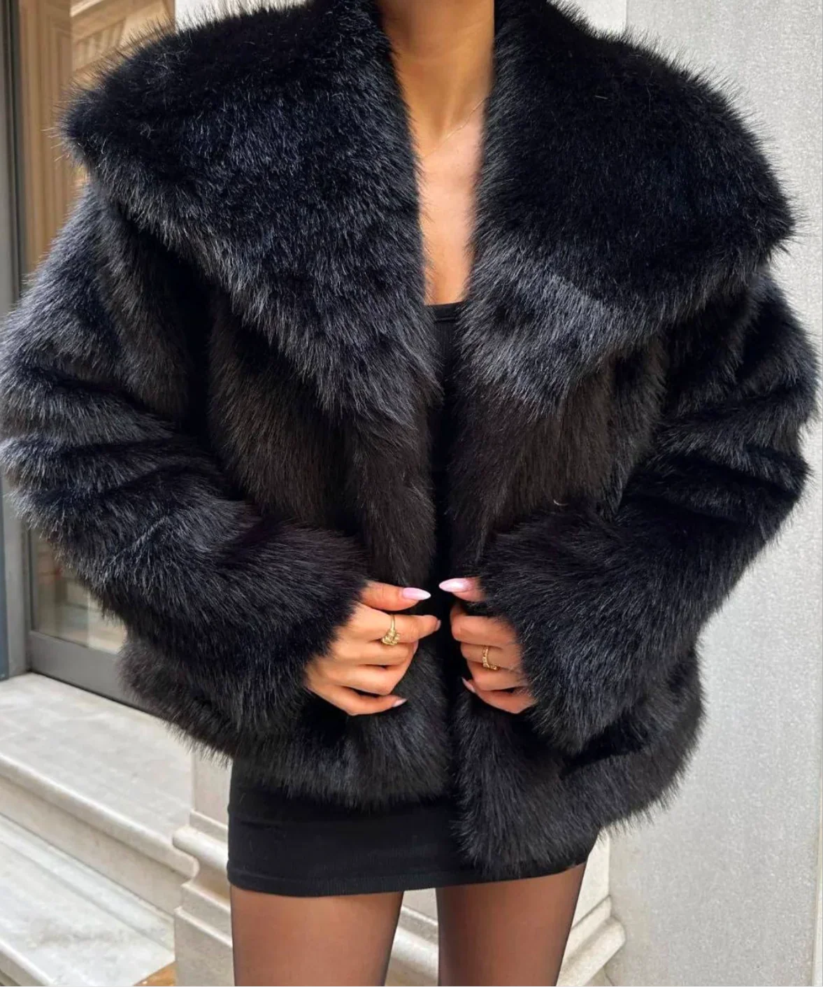 Black oversized faux fur coat with wide lapels and long sleeves