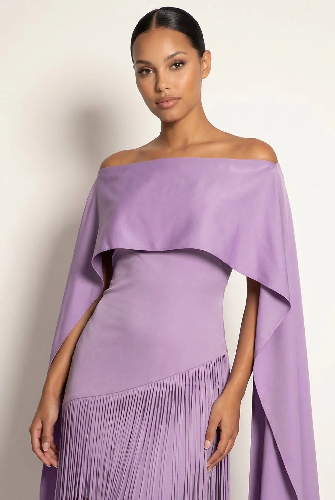 Lilac off-shoulder maxi gown with draped cape overlay and fringe skirt trim