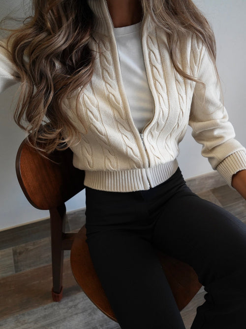 Cream high-neck zip cardigan close-up with cable knit texture and ribbed hem