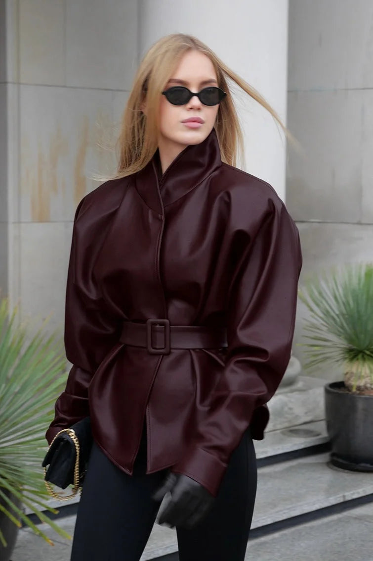 Belted faux leather jacket with zip front and structured shoulders, dark burgundy.