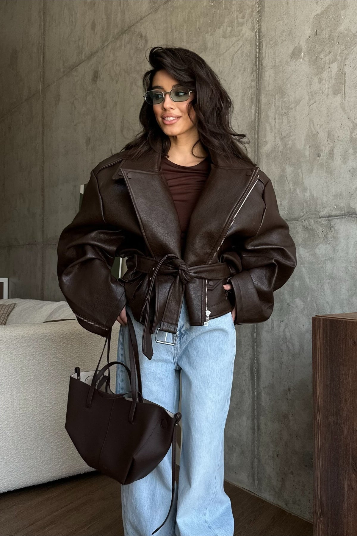 Women's dark brown faux leather moto jacket with tie belt, V-lapels and zip details