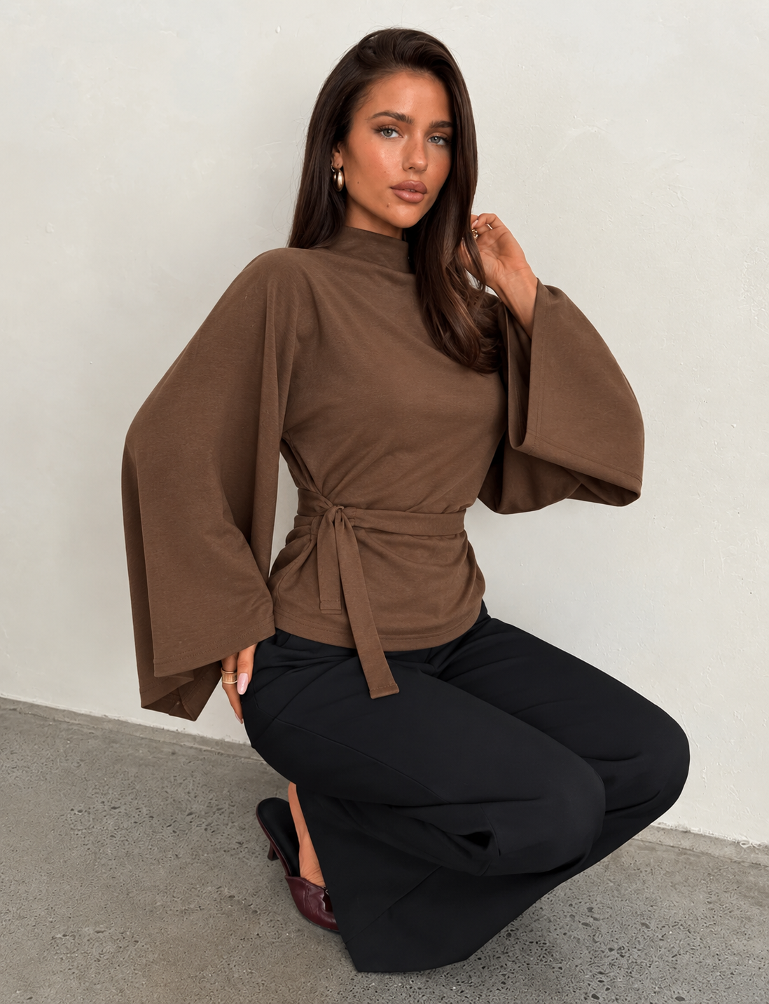 Brown knit batwing shoulder-wrap top with high neck and waist tie belt, wide sleeves