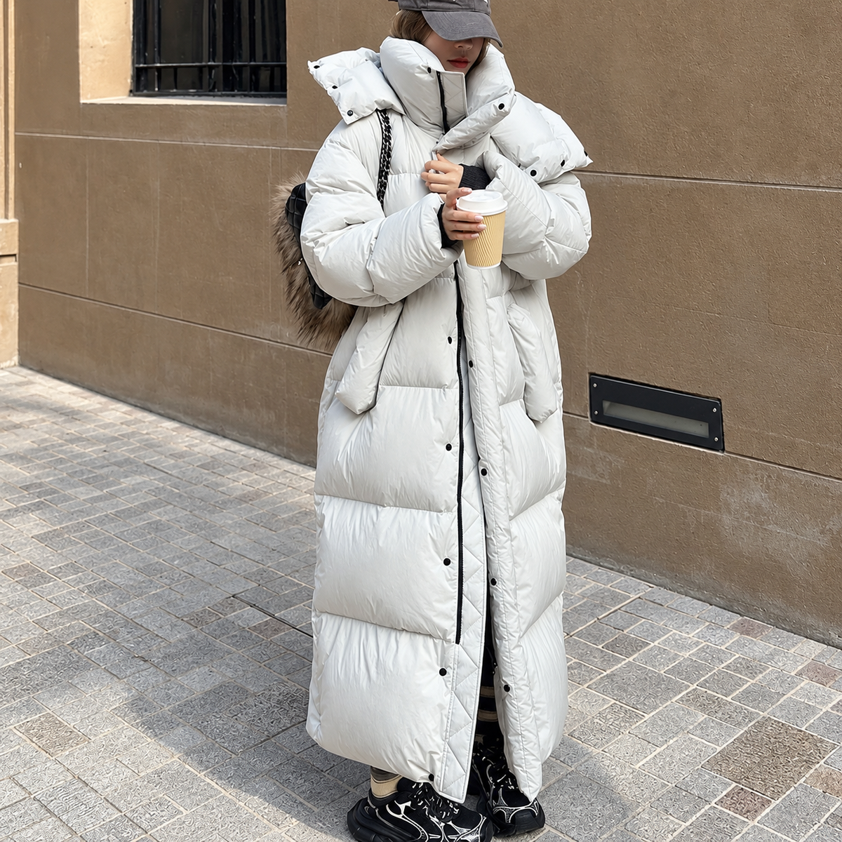 White long hooded padded coat with central button closure and padded collar