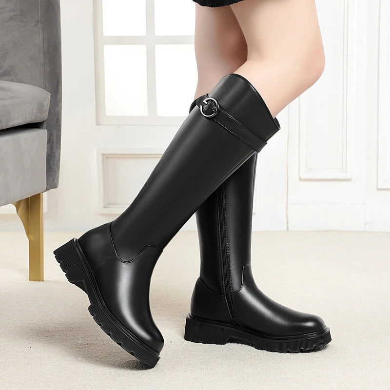 Black knee-high riding boots with buckle strap and stacked lug sole