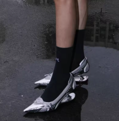 Mary Jane pumps with pointed toe, bow detail, and ankle strap in silver and black