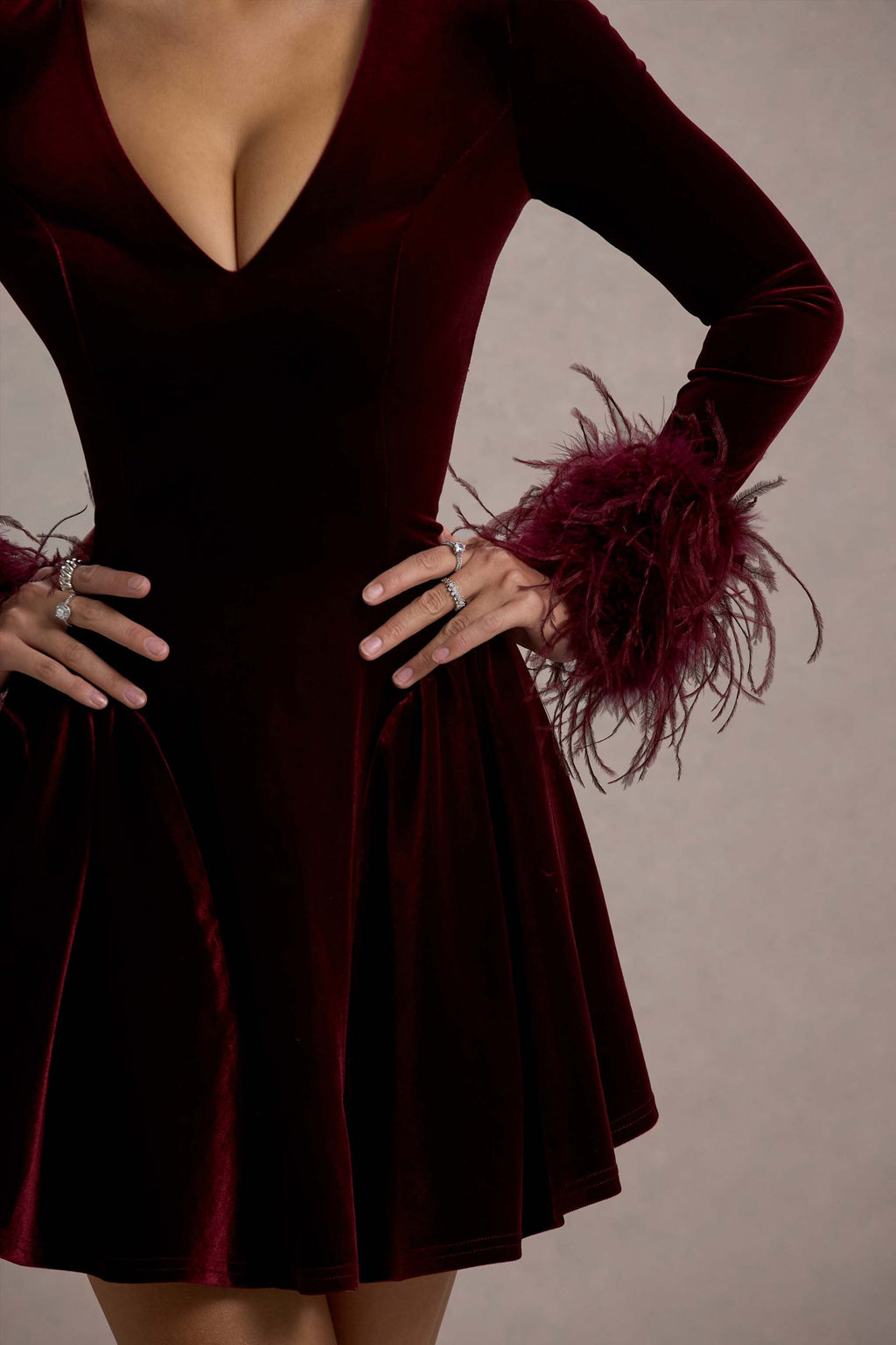 Dark red velvet bodice with deep V plunge and feather-trim sleeve detail