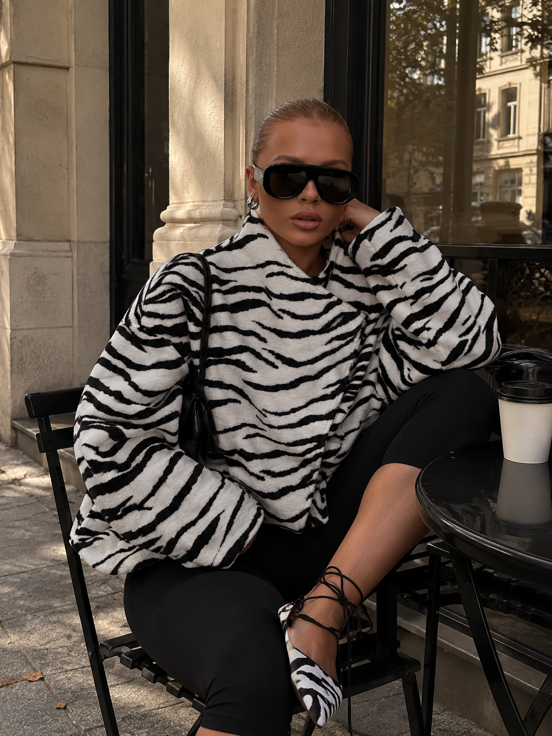 Oversized zebra-print jacket, black-and-white stripes, plush texture, high collar.