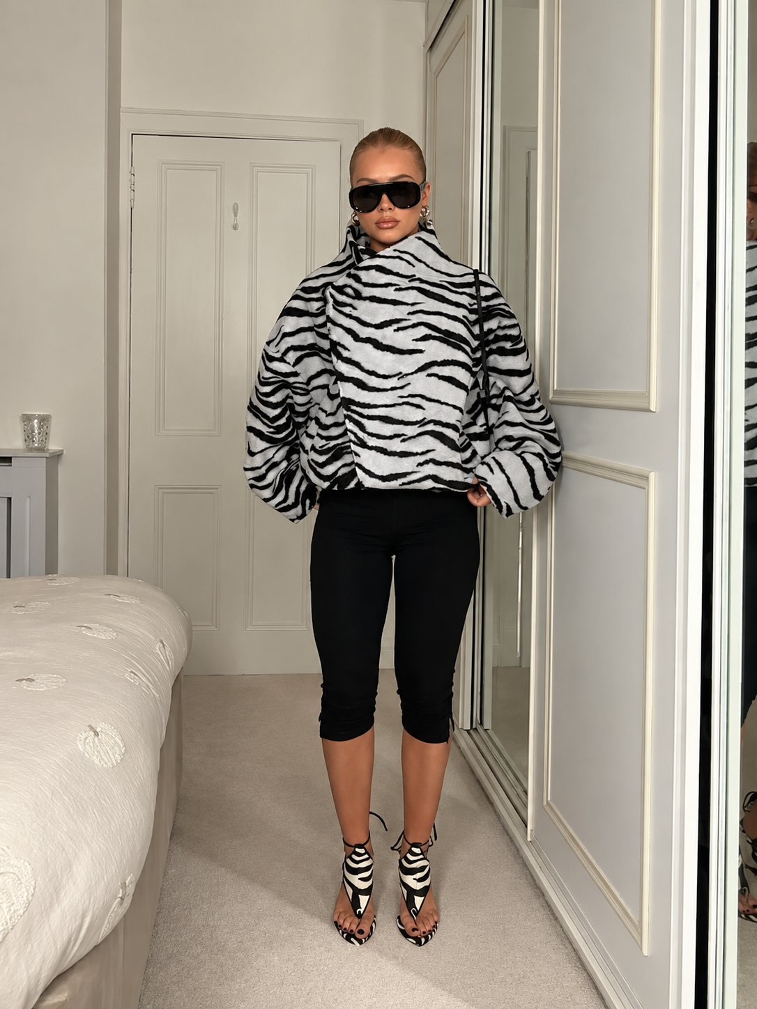 Oversized zebra-print jacket with high collar and voluminous sleeves, black-and-white.
