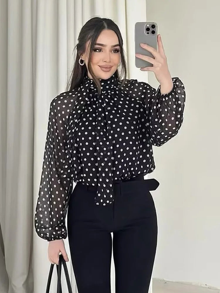 Black polka dot tie-neck blouse with long sleeves and a gathered neck bow.