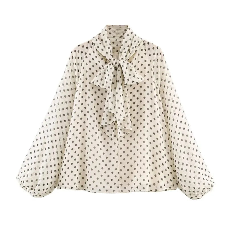 White polka dot blouse with button front, tie-neck bow, and long puff sleeves.