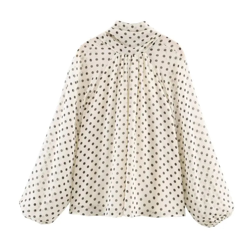 White polka dot tie-neck blouse with long balloon sleeves and a bow-tie collar.